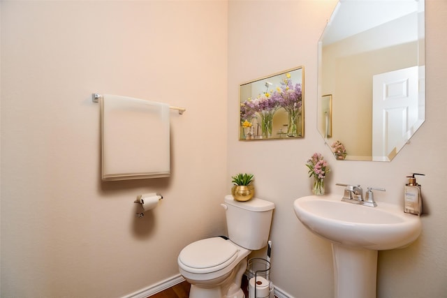 bathroom with toilet and baseboards