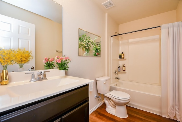 full bath featuring visible vents, washtub / shower combination, toilet, vanity, and wood finished floors