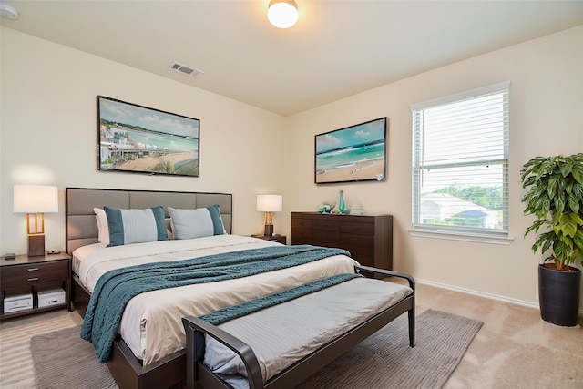 bedroom featuring visible vents, baseboards, and light colored carpet