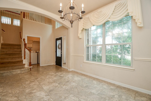entryway with a wealth of natural light, separate washer and dryer, a chandelier, and stairs