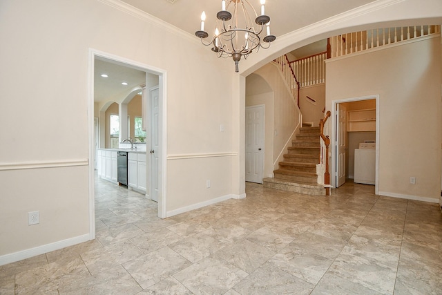 interior space featuring an inviting chandelier, washer / clothes dryer, arched walkways, stairs, and baseboards