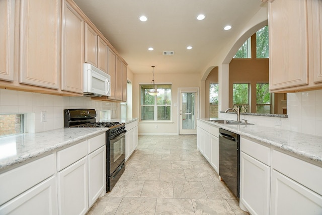 kitchen with gas stove, white microwave, visible vents, dishwasher, and a sink