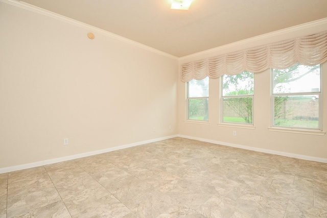 spare room with stone finish floor, baseboards, and ornamental molding