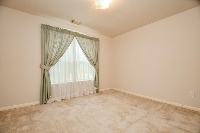 carpeted spare room with baseboards and visible vents