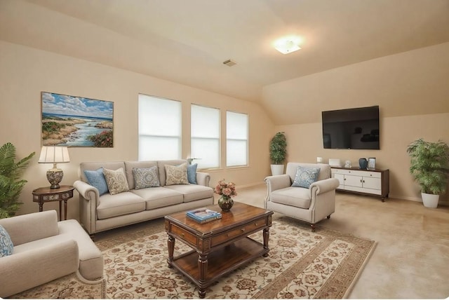 living area featuring vaulted ceiling, visible vents, baseboards, and light carpet
