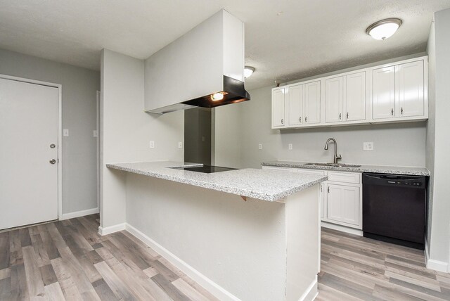 kitchen with light wood-style floors, a peninsula, white cabinetry, black appliances, and a sink