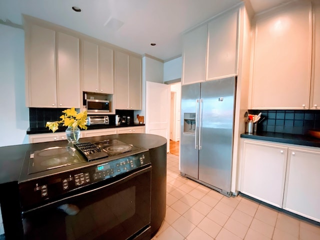 1964 Norfolk St, Houston, TX 77098 - kitchen featuring stainless steel appliances, dark countertops, tasteful backsplash, white cabinets, and light tile patterned floors