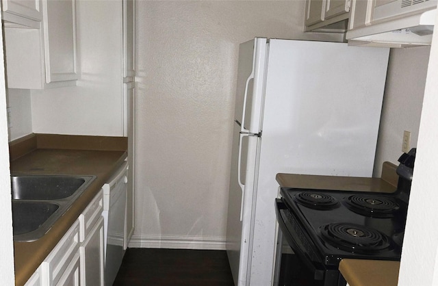 kitchen featuring black electric range, a sink, white cabinetry, and baseboards