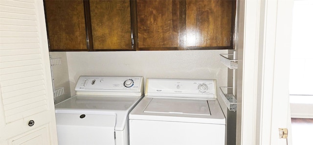 laundry room featuring separate washer and dryer and cabinet space