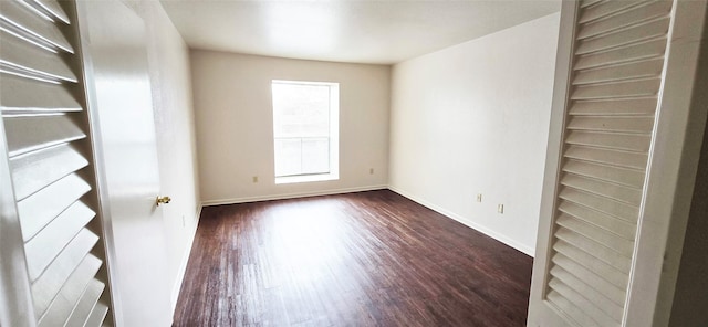 unfurnished bedroom featuring dark wood-type flooring and baseboards