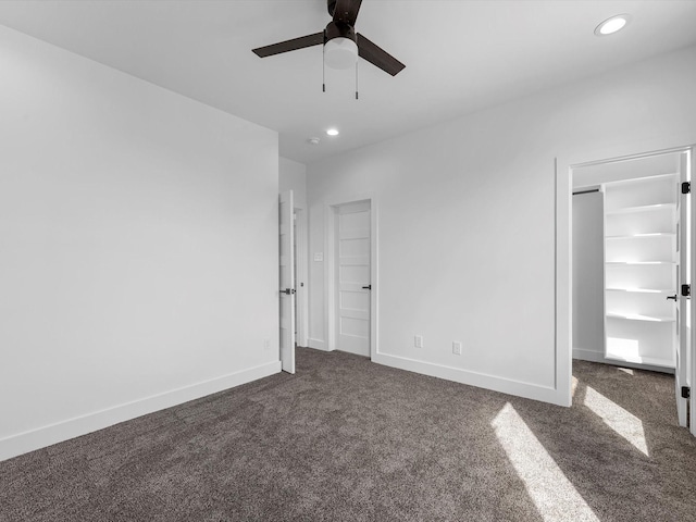 1130 Miller Rd, Sealy, TX 77474 - unfurnished bedroom with a walk in closet, baseboards, recessed lighting, and dark colored carpet