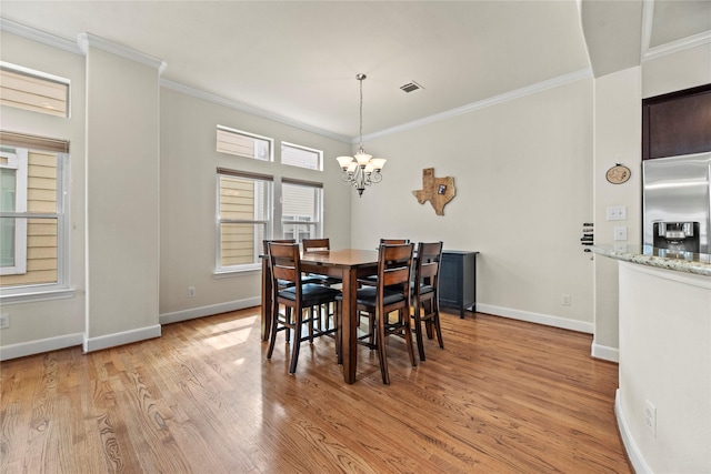 5329 Kansas St, Houston, TX 77007 - dining space with ornamental molding, baseboards, a chandelier, and light wood-style floors