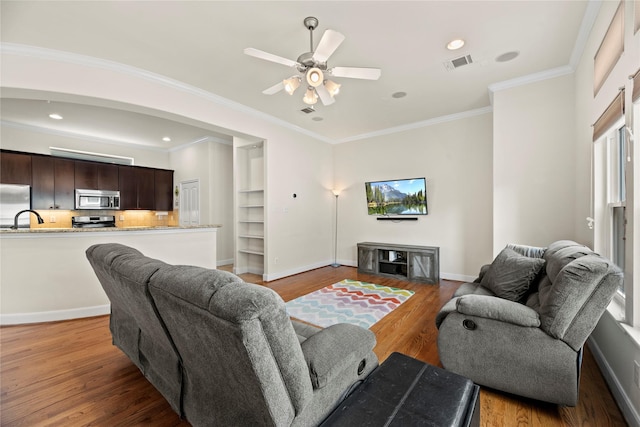 5329 Kansas St, Houston, TX 77007 - living room featuring visible vents, baseboards, ornamental molding, ceiling fan, and light wood finished floors