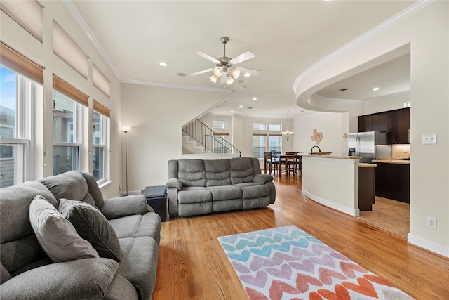 5329 Kansas St, Houston, TX 77007 - living area featuring ornamental molding, light wood finished floors, recessed lighting, ceiling fan with notable chandelier, and stairs