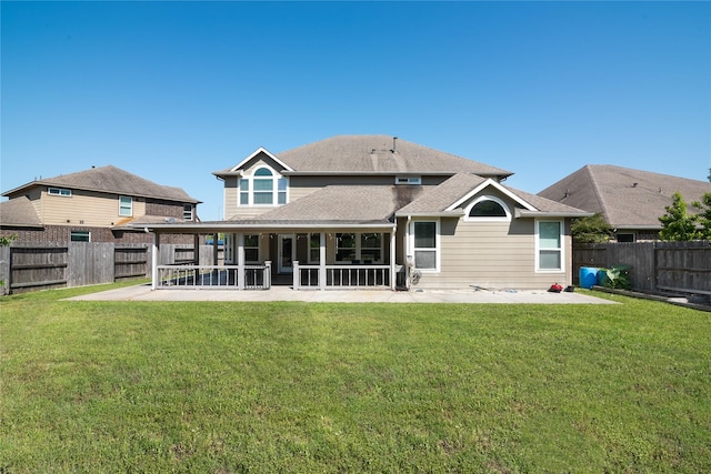 rear view of house featuring roof with shingles, a patio area, a fenced backyard, and a lawn