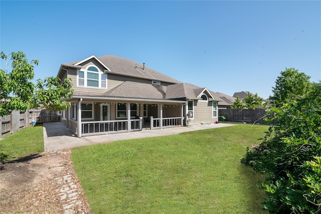 rear view of house with a patio, a fenced backyard, and a lawn
