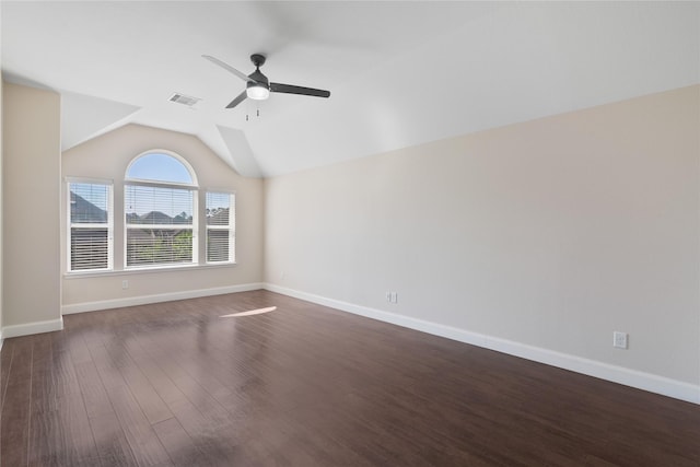 spare room featuring dark wood-style flooring, baseboards, visible vents, lofted ceiling, and ceiling fan