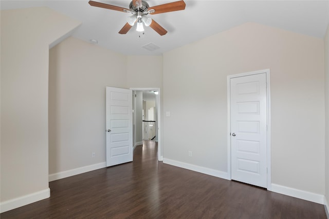 unfurnished bedroom featuring dark wood-style flooring, baseboards, and vaulted ceiling