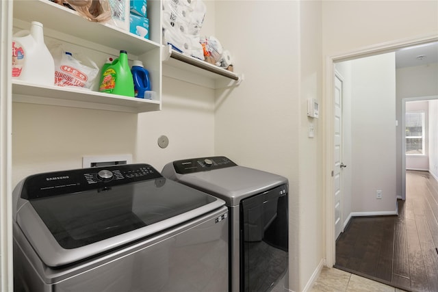 laundry room featuring washer and clothes dryer, wood finished floors, laundry area, and baseboards