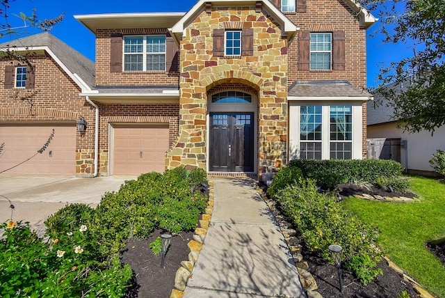 10219 Wylde Point Ln, Missouri City, TX 77459 - view of front of home with brick siding, driveway, stone siding, and a garage