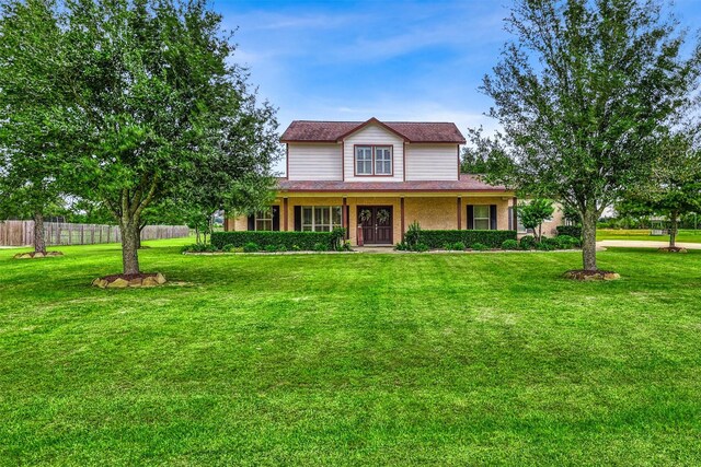 3026 Dees Cir, Sealy, TX 77474 - traditional-style home featuring a front lawn, covered porch, and fence