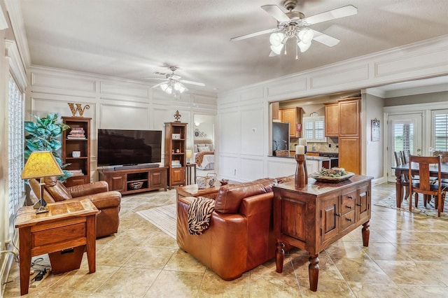 3026 Dees Cir, Sealy, TX 77474 - living area with crown molding, light tile patterned floors, a decorative wall, and ceiling fan