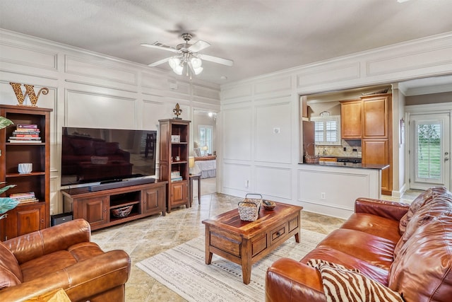 3026 Dees Cir, Sealy, TX 77474 - living area featuring crown molding, a decorative wall, and a ceiling fan