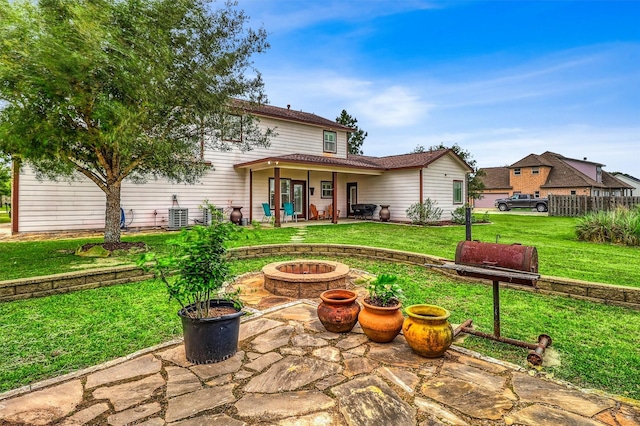 3026 Dees Cir, Sealy, TX 77474 - rear view of house featuring cooling unit, a patio area, a fire pit, and a lawn