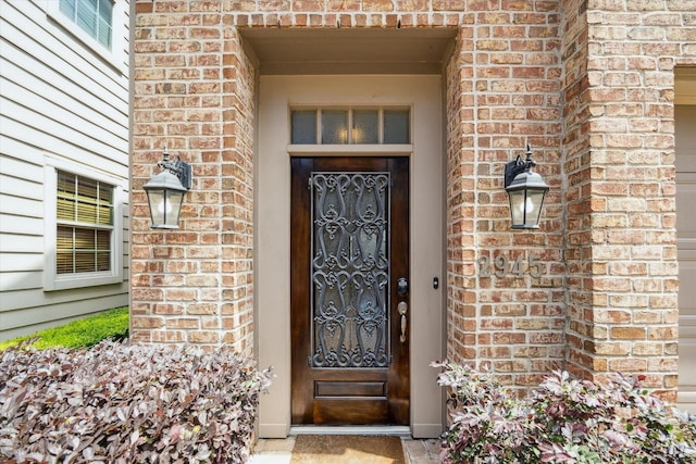 view of exterior entry featuring brick siding