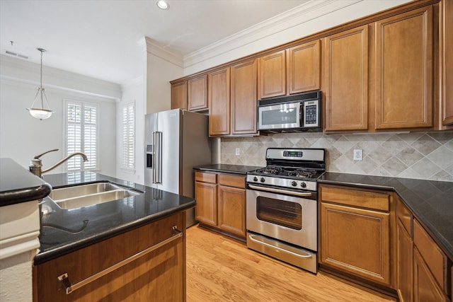 kitchen with decorative backsplash, stainless steel appliances, brown cabinets, a sink, and crown molding