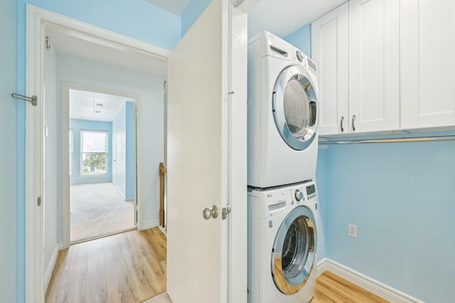 7463 Brompton St Unit 7463, Houston, TX 77025 - laundry room featuring estacked washer and dryer, light wood-style flooring, and baseboards
