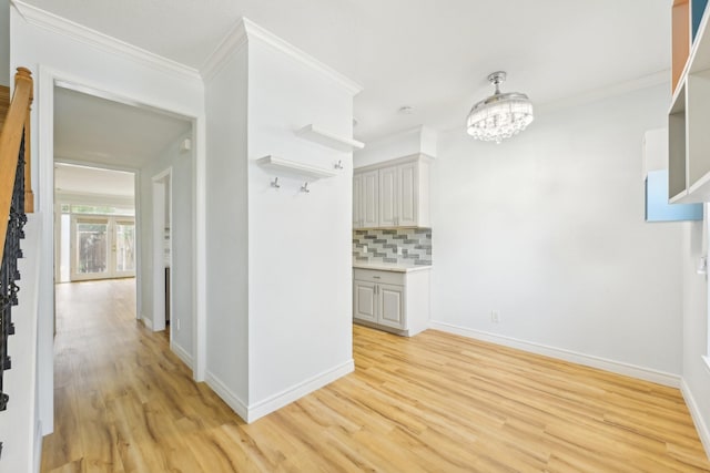 7463 Brompton St Unit 7463, Houston, TX 77025 - hallway with light wood-type flooring, baseboards, ornamental molding, and a chandelier