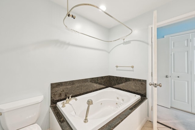 7463 Brompton St Unit 7463, Houston, TX 77025 - bathroom featuring a whirlpool tub, toilet, and tile patterned flooring