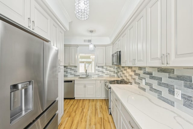 7463 Brompton St Unit 7463, Houston, TX 77025 - kitchen with stainless steel appliances, ornamental molding, a sink, a chandelier, and backsplash