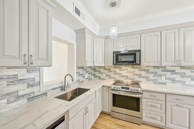 7463 Brompton St Unit 7463, Houston, TX 77025 - kitchen with stainless steel electric range, a sink, hanging light fixtures, light stone counters, and crown molding