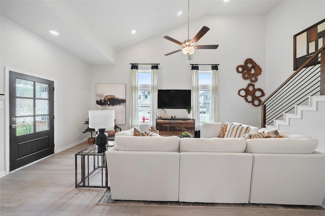 living area featuring high vaulted ceiling, plenty of natural light, light wood-style floors, and recessed lighting