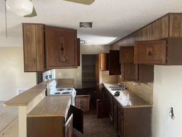 kitchen with visible vents, a sink, a textured ceiling, vaulted ceiling, and white electric range oven