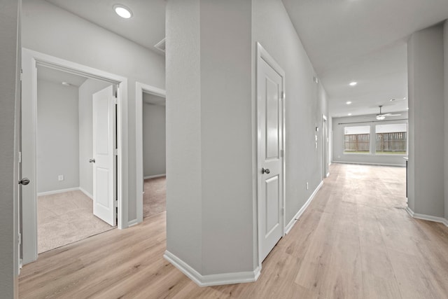 corridor featuring recessed lighting, light wood-style floors, and baseboards