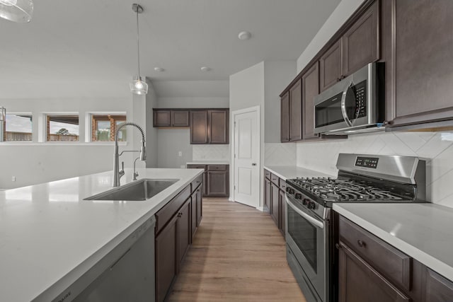 kitchen with a sink, light countertops, dark brown cabinetry, and stainless steel appliances