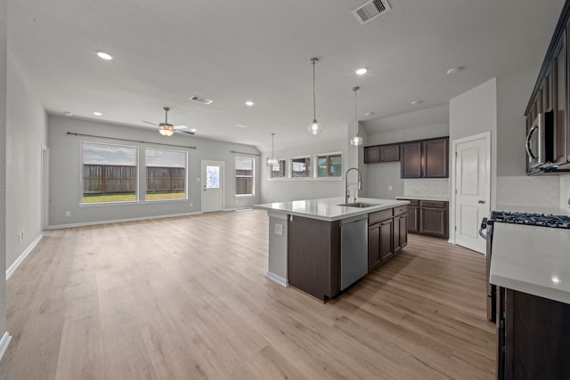 kitchen with light wood-type flooring, visible vents, appliances with stainless steel finishes, light countertops, and open floor plan