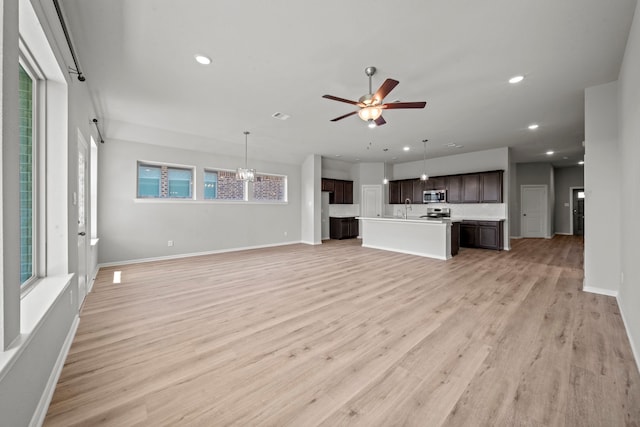 unfurnished living room with light wood-type flooring, baseboards, recessed lighting, visible vents, and ceiling fan with notable chandelier