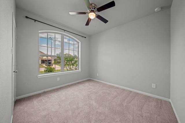 unfurnished room featuring baseboards, ceiling fan, and carpet