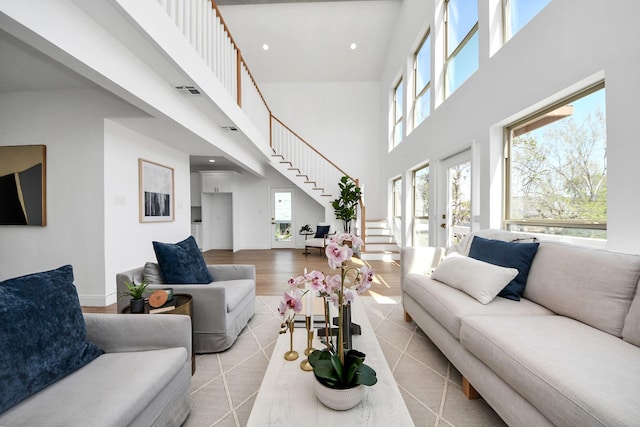 300 Narcissus Rd, Clear Lake Shores, TX 77565 - living area with baseboards, recessed lighting, stairway, a high ceiling, and light wood-style floors