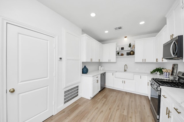 300 Narcissus Rd, Clear Lake Shores, TX 77565 - kitchen featuring a sink, visible vents, open shelves, and stainless steel appliances