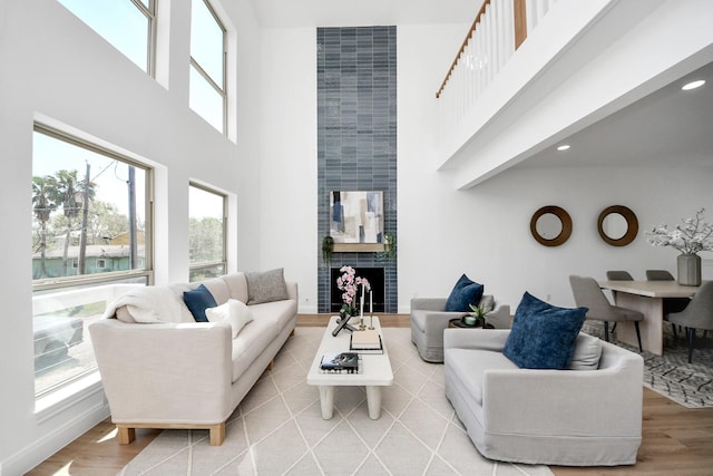 300 Narcissus Rd, Clear Lake Shores, TX 77565 - living room featuring light wood-style floors, a high ceiling, a large fireplace, and recessed lighting