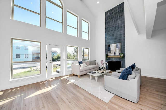 300 Narcissus Rd, Clear Lake Shores, TX 77565 - living room with wood finished floors, high vaulted ceiling, a fireplace, and baseboards