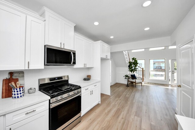 300 Narcissus Rd, Clear Lake Shores, TX 77565 - kitchen with light stone counters, recessed lighting, white cabinets, and stainless steel appliances