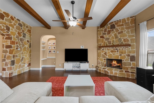 321 Westwood Dr, League City, TX 77573 - living room with ceiling fan, wood finished floors, a fireplace, beamed ceiling, and arched walkways