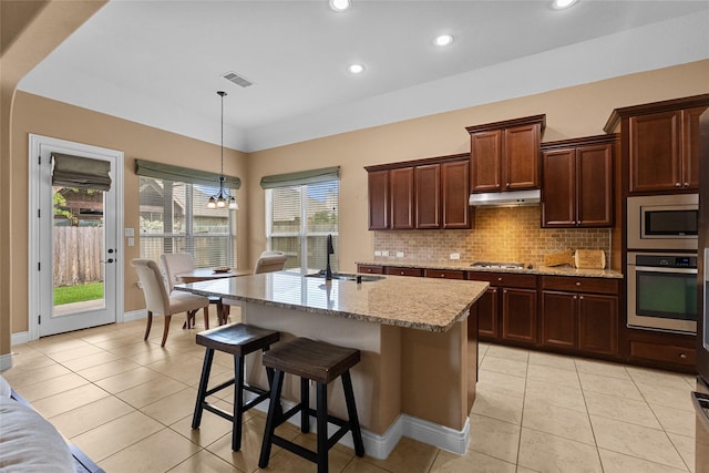 321 Westwood Dr, League City, TX 77573 - kitchen featuring appliances with stainless steel finishes, a sink, light tile patterned floors, light stone counters, and backsplash