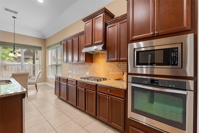 321 Westwood Dr, League City, TX 77573 - kitchen featuring appliances with stainless steel finishes, light tile patterned flooring, backsplash, light stone counters, and lofted ceiling